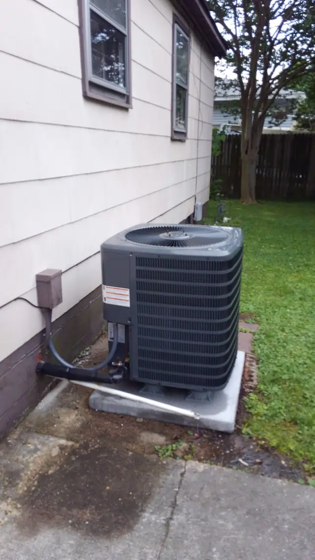 Air conditioner condenser beside a house