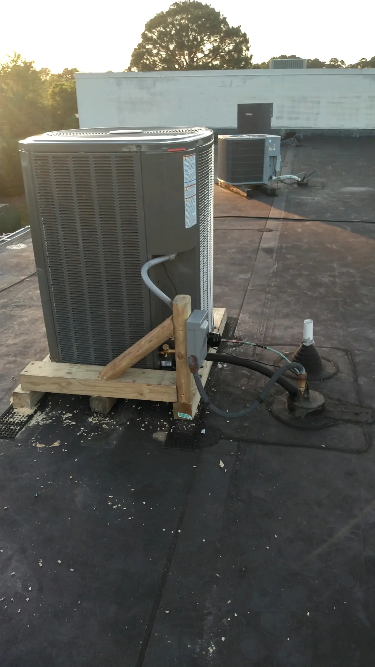 Commercial condensing unit on a flat roof serviced by Ace Mechanical